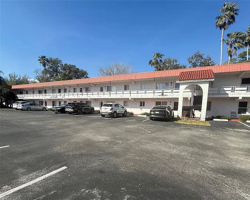 An Orchid Springs Village building and parking area under a blue sky