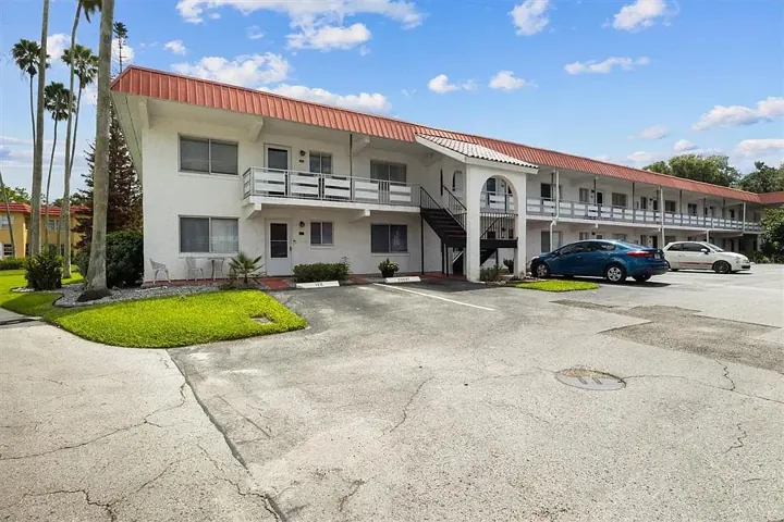 Two-story residential building with parked cars